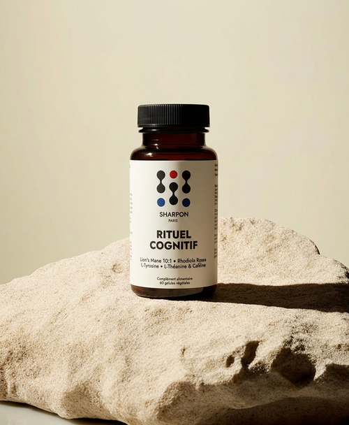 Bottle of sharpon rituel cognitif (nootropic) on a rock with a neutral background